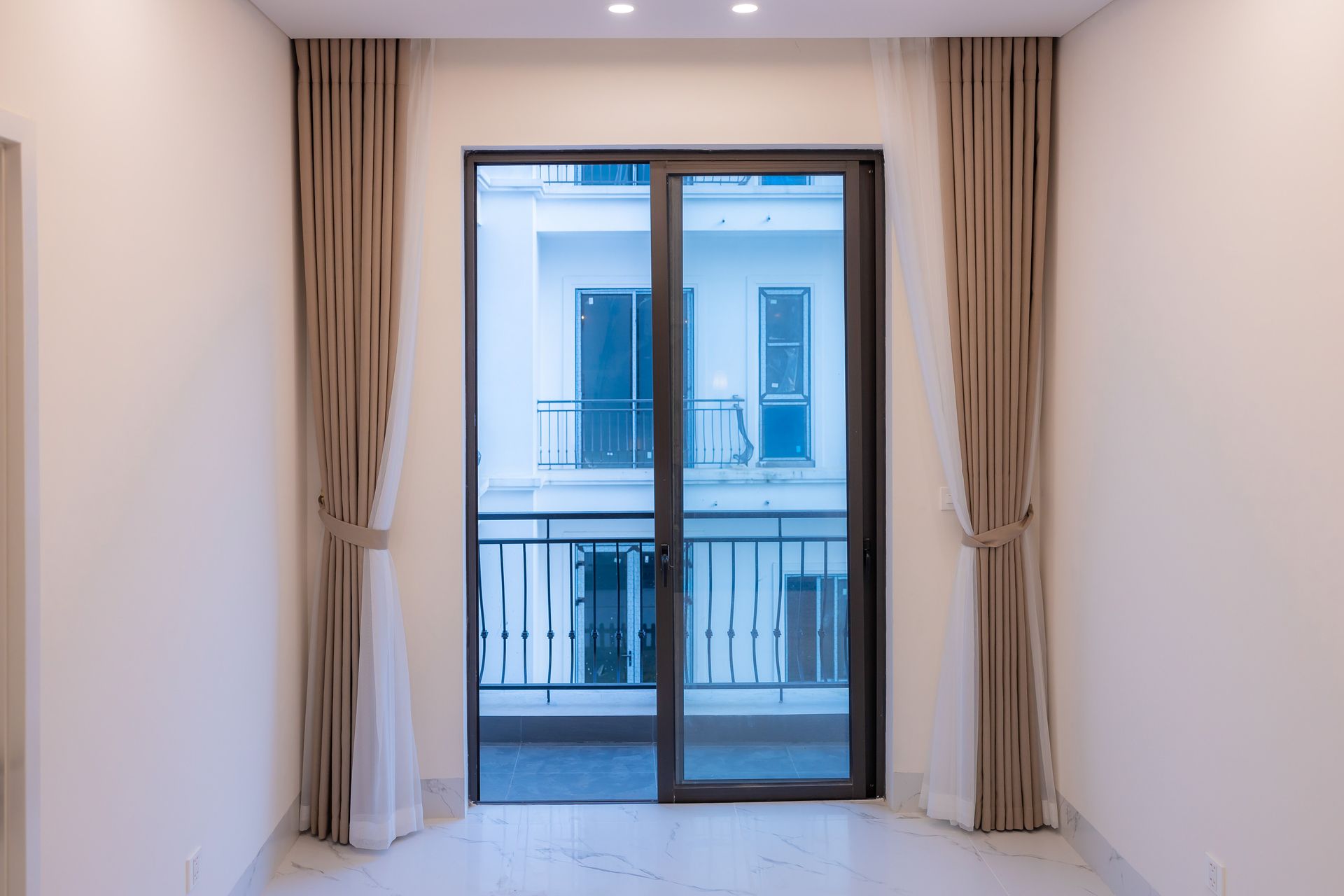 Porte-fenêtre aluminium anthracite ouvrant sur un balcon